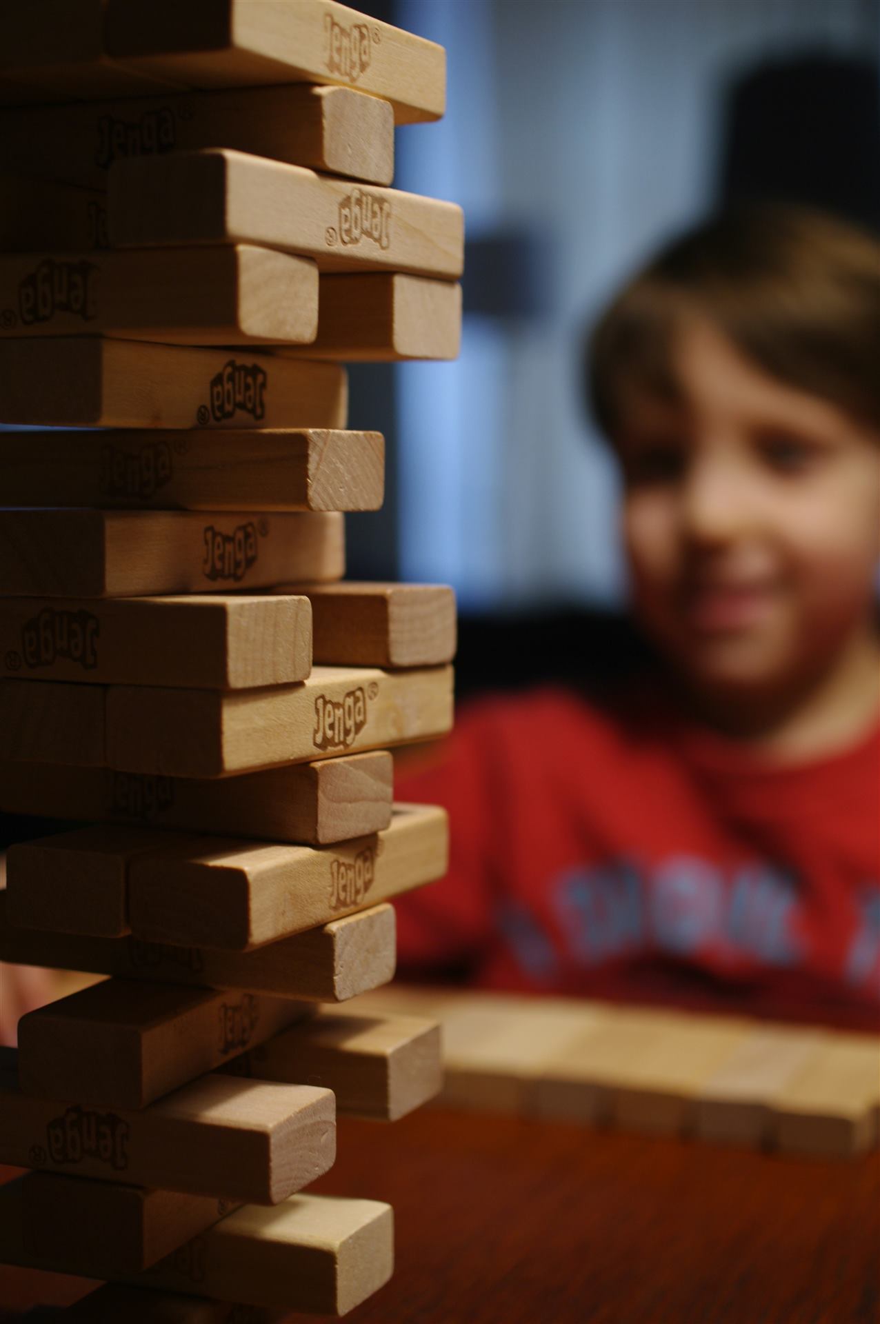 Criança sorrindo em um jogo de torre de blocos